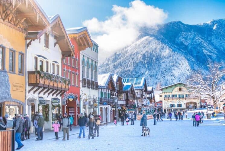 Quaint Bavarian village in a golden glow covered in freshly fallen snow under a night sky