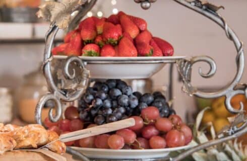 Two-tiered decorative serving platter with grapes, blueberries and strawberries