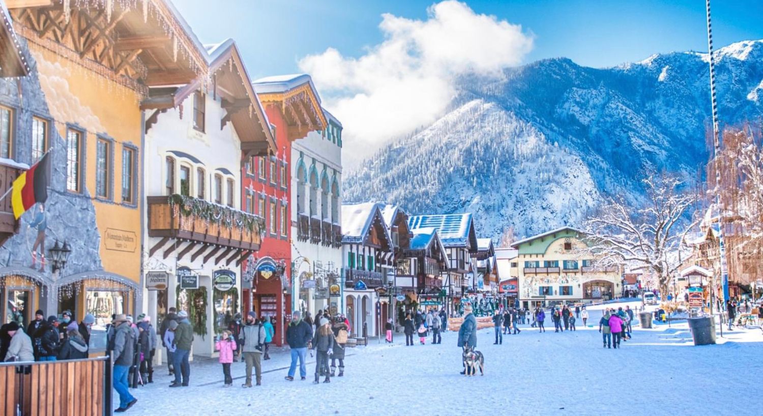 Main street of a mountain town during winter with shoppers walking among colorful business buildings