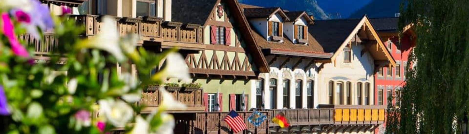 A row of colorful buildings in a Bavarian-style town with mountain range behind