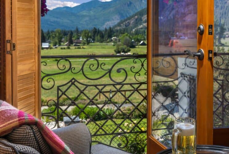 An open patio door overlooking a vast valley and mountain range